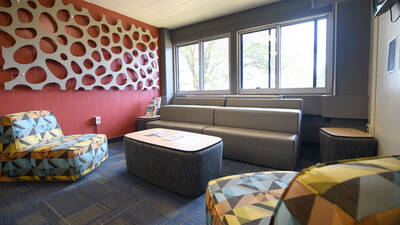 Horan Hall lobby with colorful chairs, a couch, and side tables.