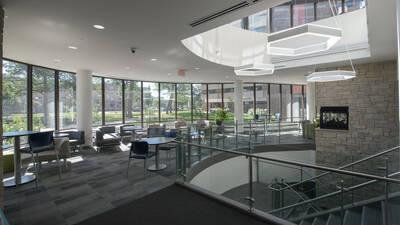 Towers Hall common area with lots of tables and chairs with natural light.