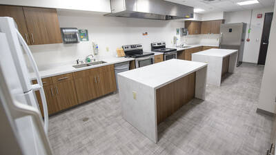 Kitchen space in Towers Hall with ovens, sinks, cabinets, fridges, and counter space.