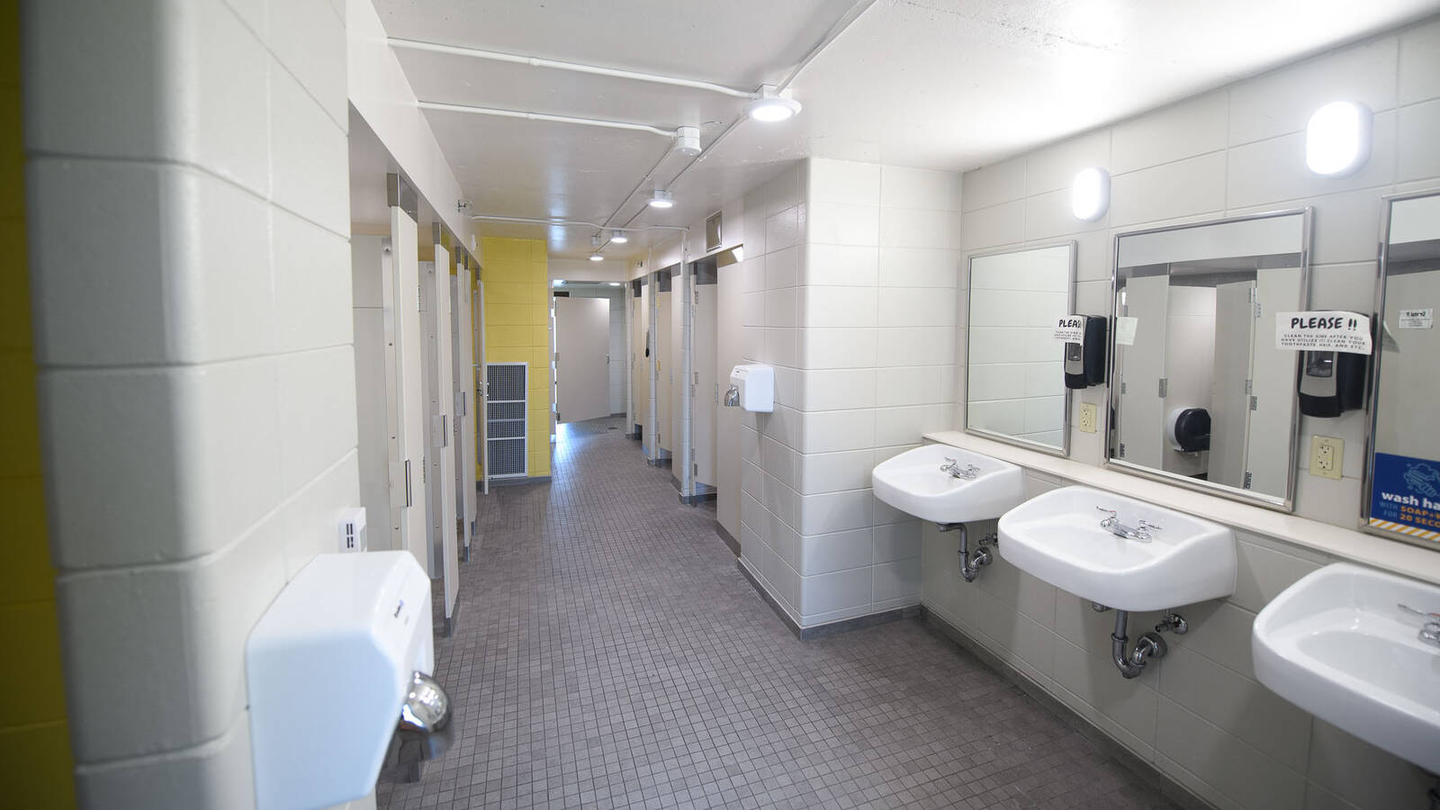 Bathroom in Towers Hall with sinks, stalls, and showers.