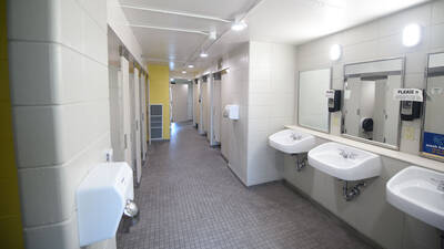 Bathroom in Towers Hall with sinks, stalls, and showers.