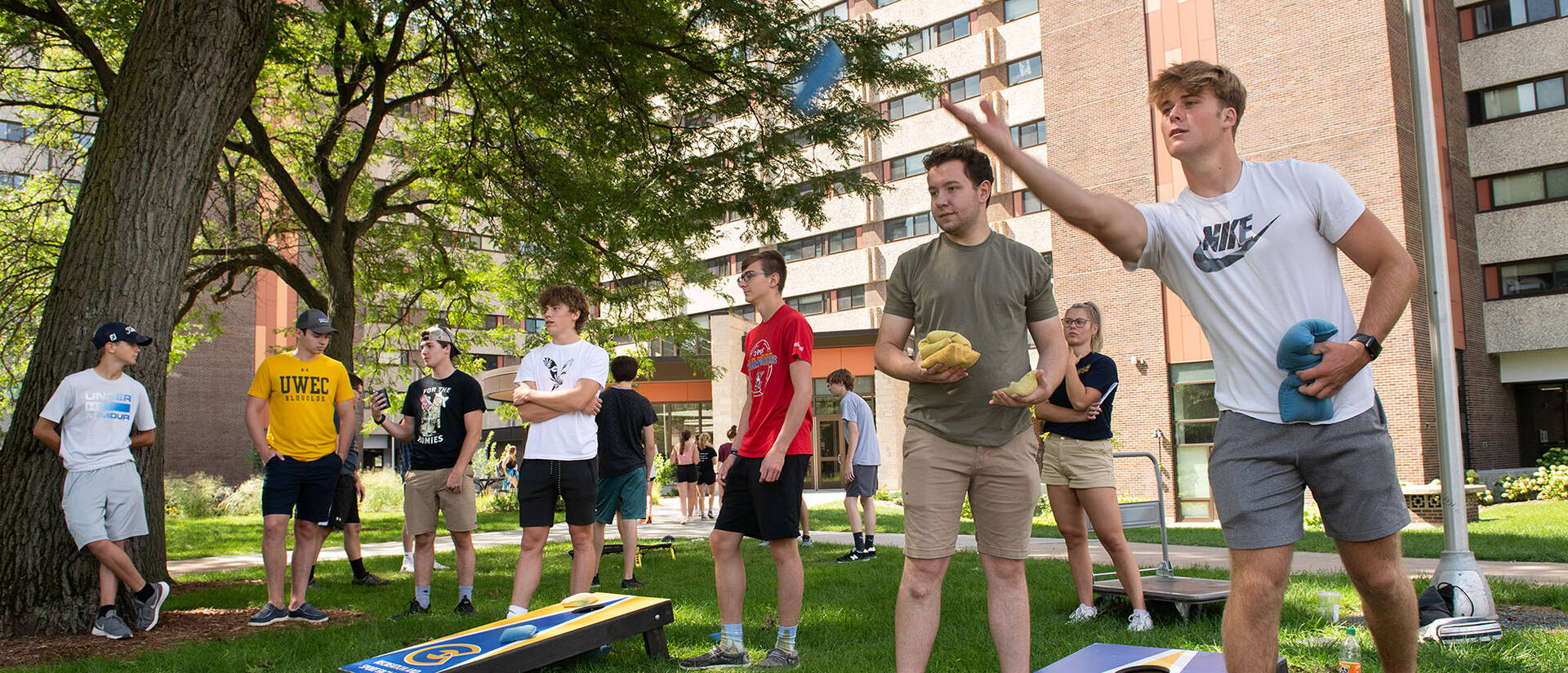 Students playing bean bag toss in front of Towers Dorms.