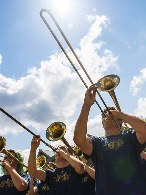 Band plays horns with a blue sky in the background.