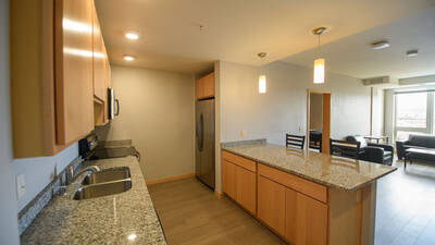 Apartment kitchen with stainless steel appliances, wood cabinets and granite countertops
