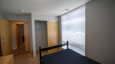 Single room facing entrance and showing an open closet