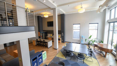 Common space in Haymarket Landing with kitchen, piano and seating for socializing