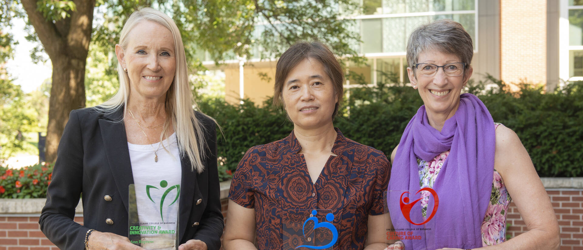 Ann Rupnow, Ling Liu, and Jean Pratt smile while holding awards received from the College of Business