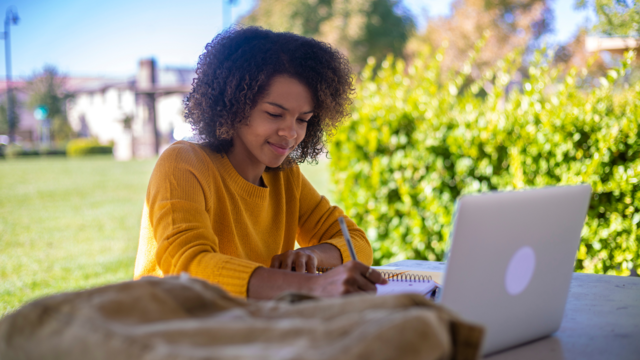 Student outdoors with laptop