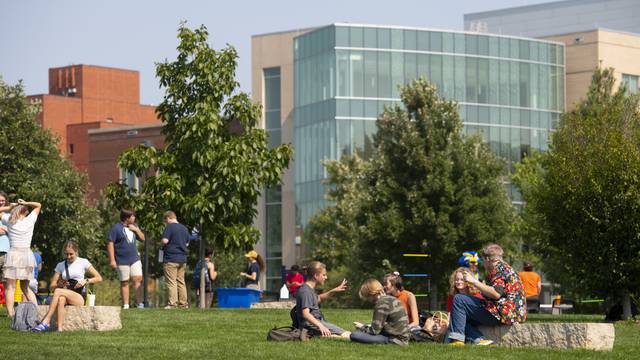 Summer campus photo with students and Centennial Hall