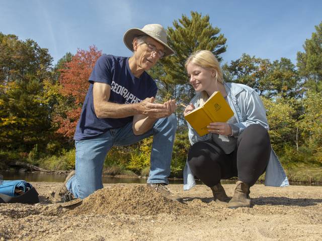 Dr. Douglas Faulkner, professor of geography, and Grace Bowe, an environmental studies major, examine the banks of western Wisconsin rivers as part of a faculty-undergraduate student research project. (Photo by Shane Opatz)