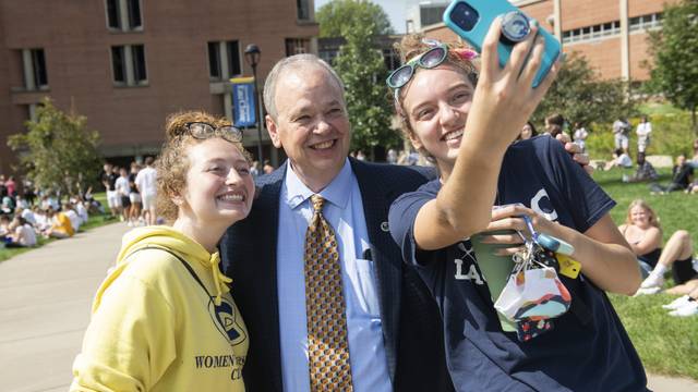 Two students taking a photo with the Chancellor