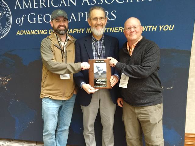 The male geographers holding an award