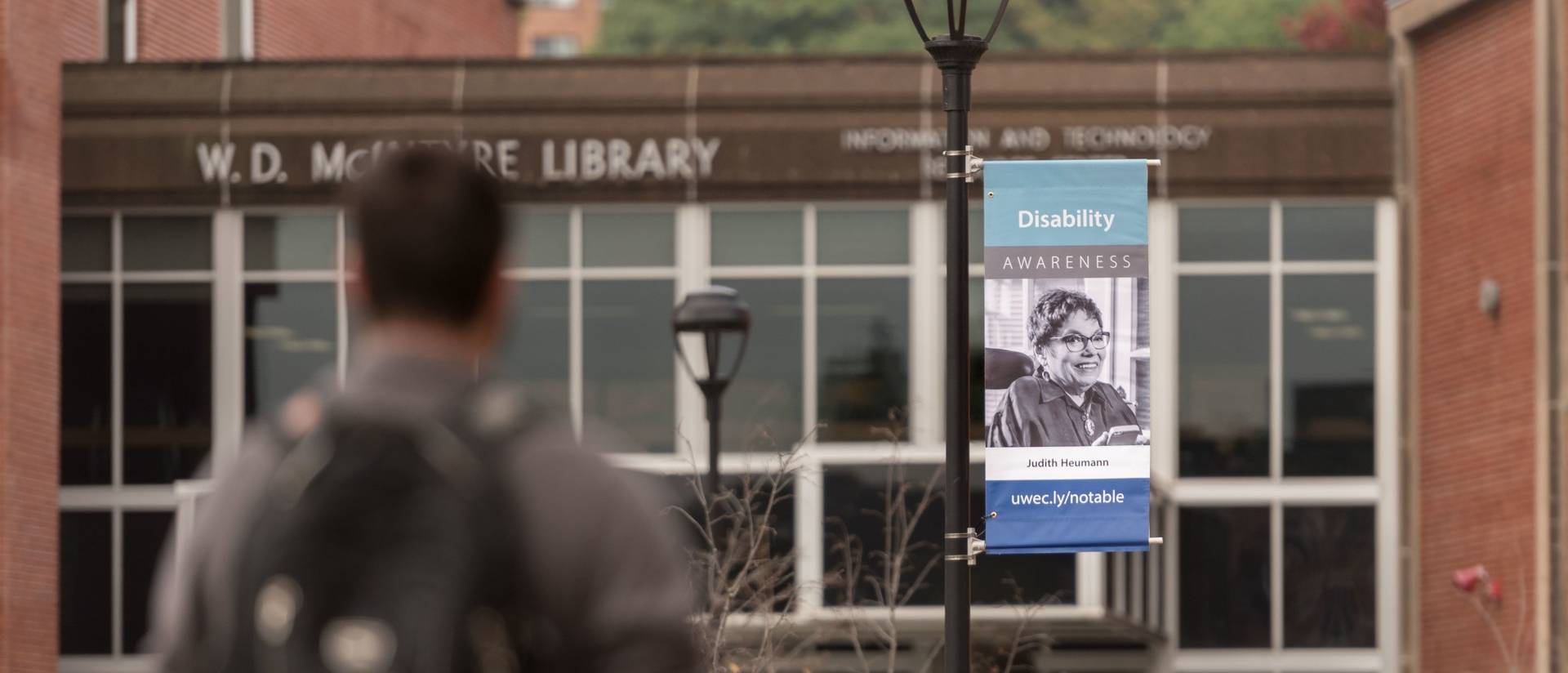 A banner of advocate Judith Heumann outside of McIntyre Library on campus