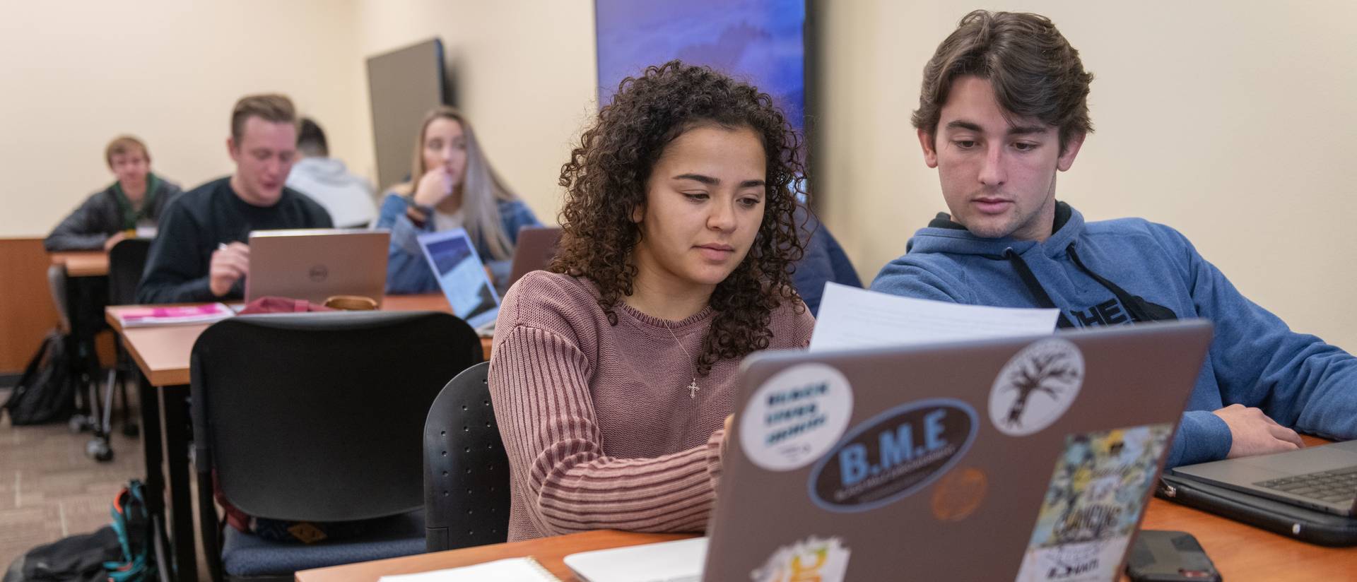 Students look at laptops during a business class.