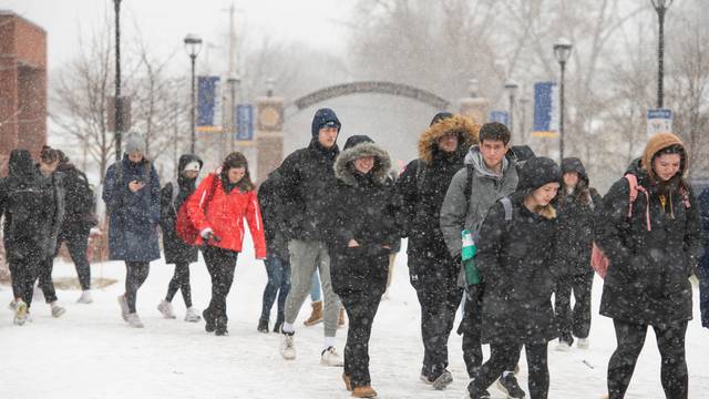 Students walk through campus on a snowy day