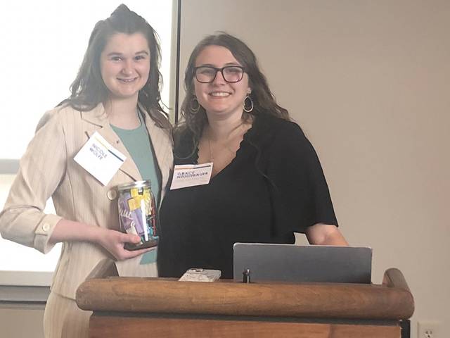 two female students at a podium