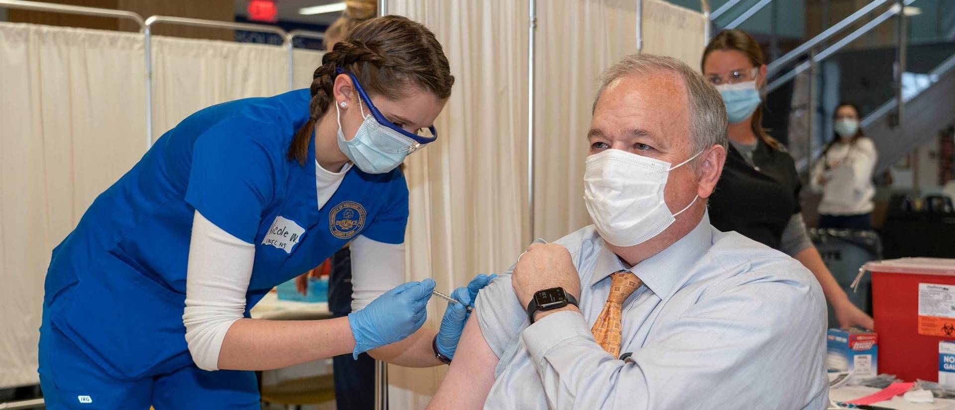 Chancellor Schmidt receiving a vaccination from a nursing student
