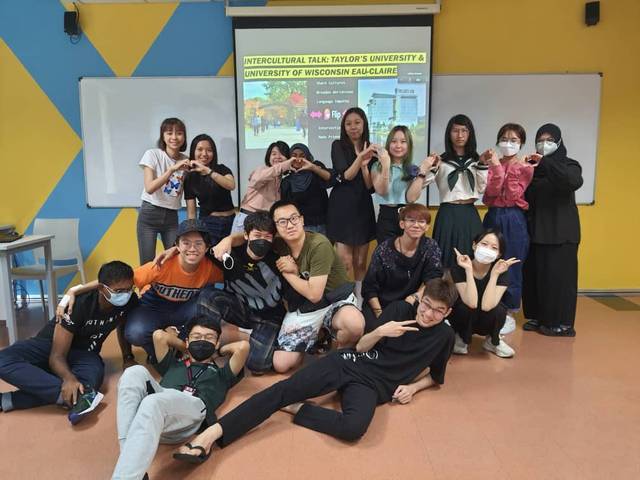 Students posing in front of a projector screen