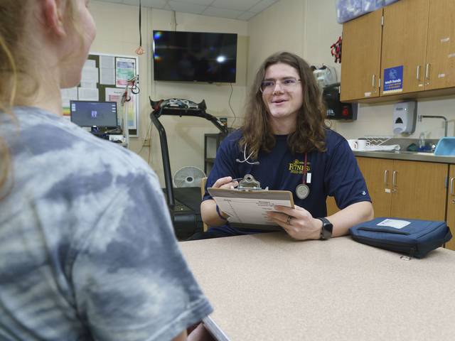 Male KINS student doing a vitals assessment for a female student