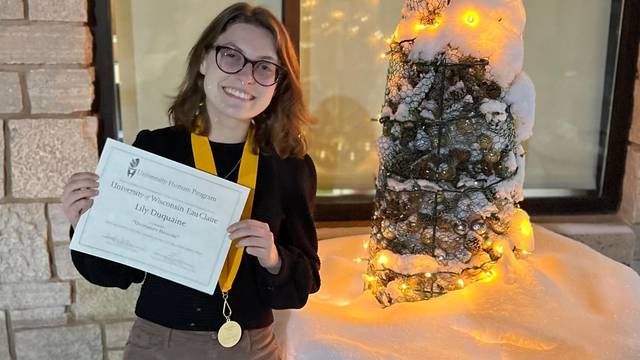 Smiling Lily Duquaine poses with her Honors medallion and certificate