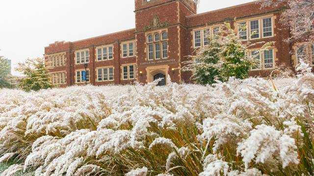 Schofield Hall in the background of snowy wild grasses.