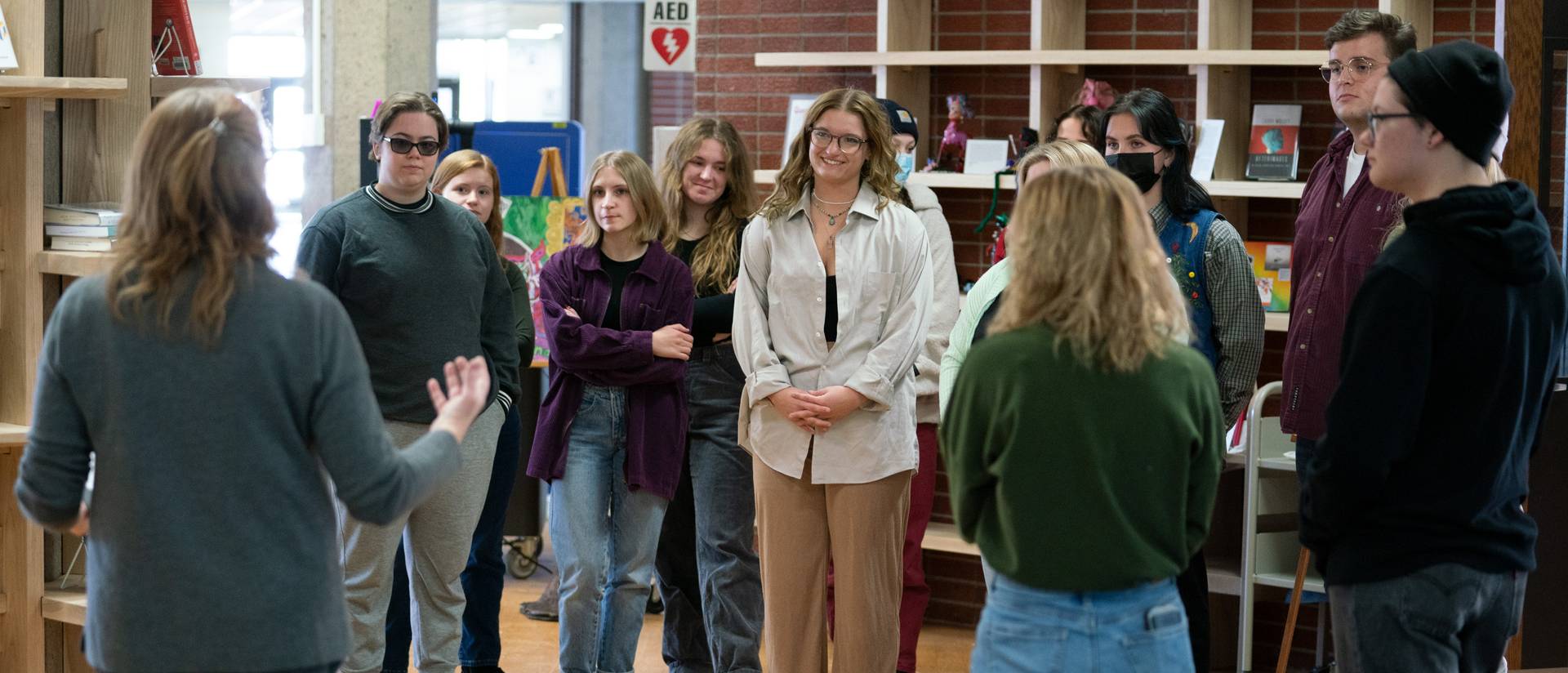 Prof Mahaffy speaking to students in front of art exhibit