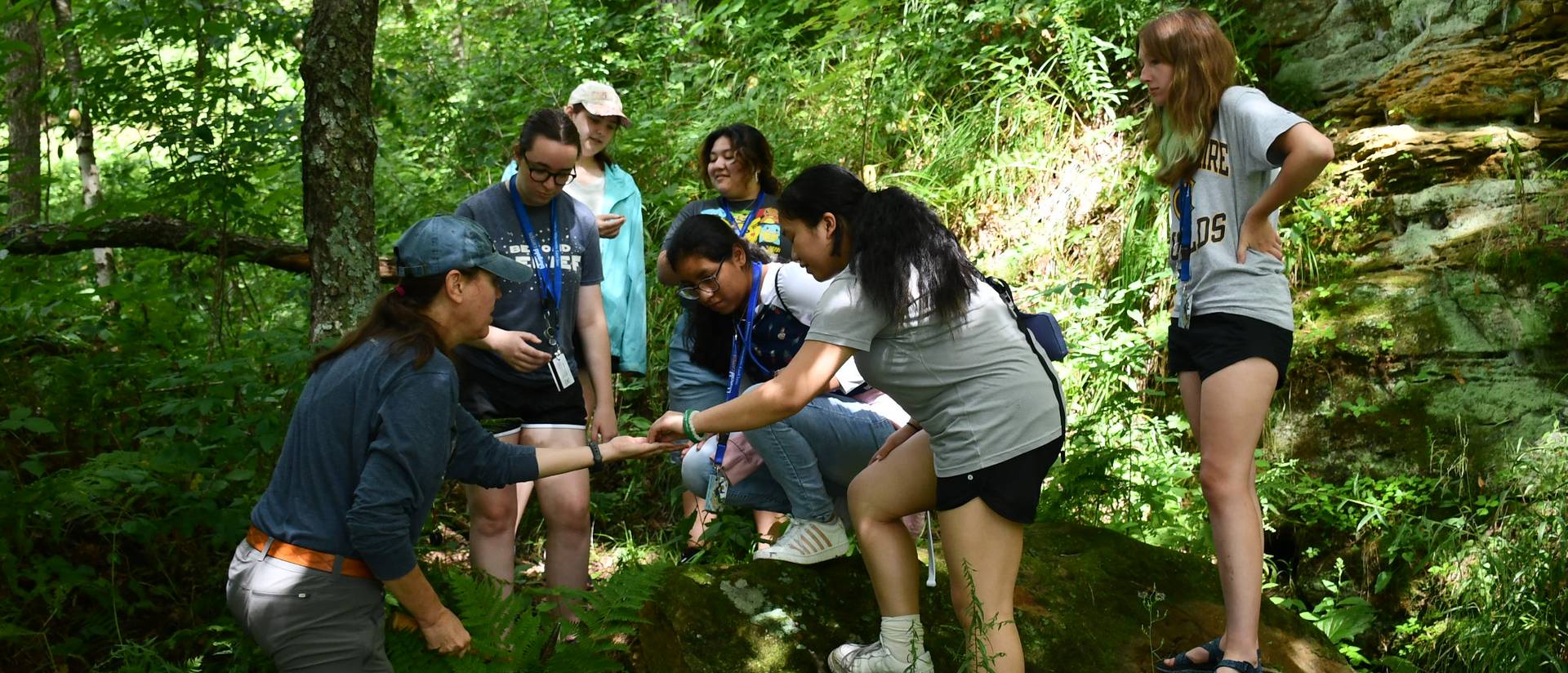 A group of students looking at artifacts in the woods