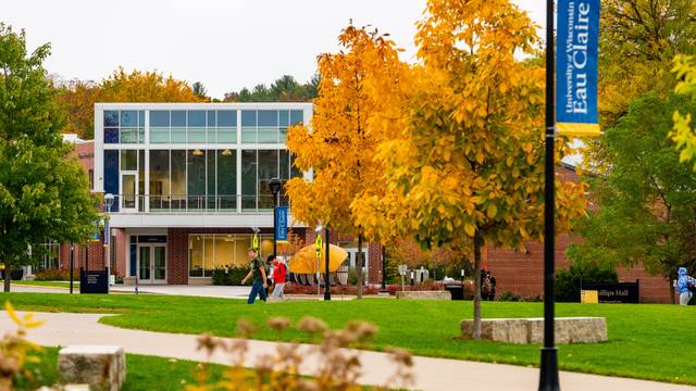 Students make their way through lower campus on a warm fall day.  The Welcome Center can be seen in the background.