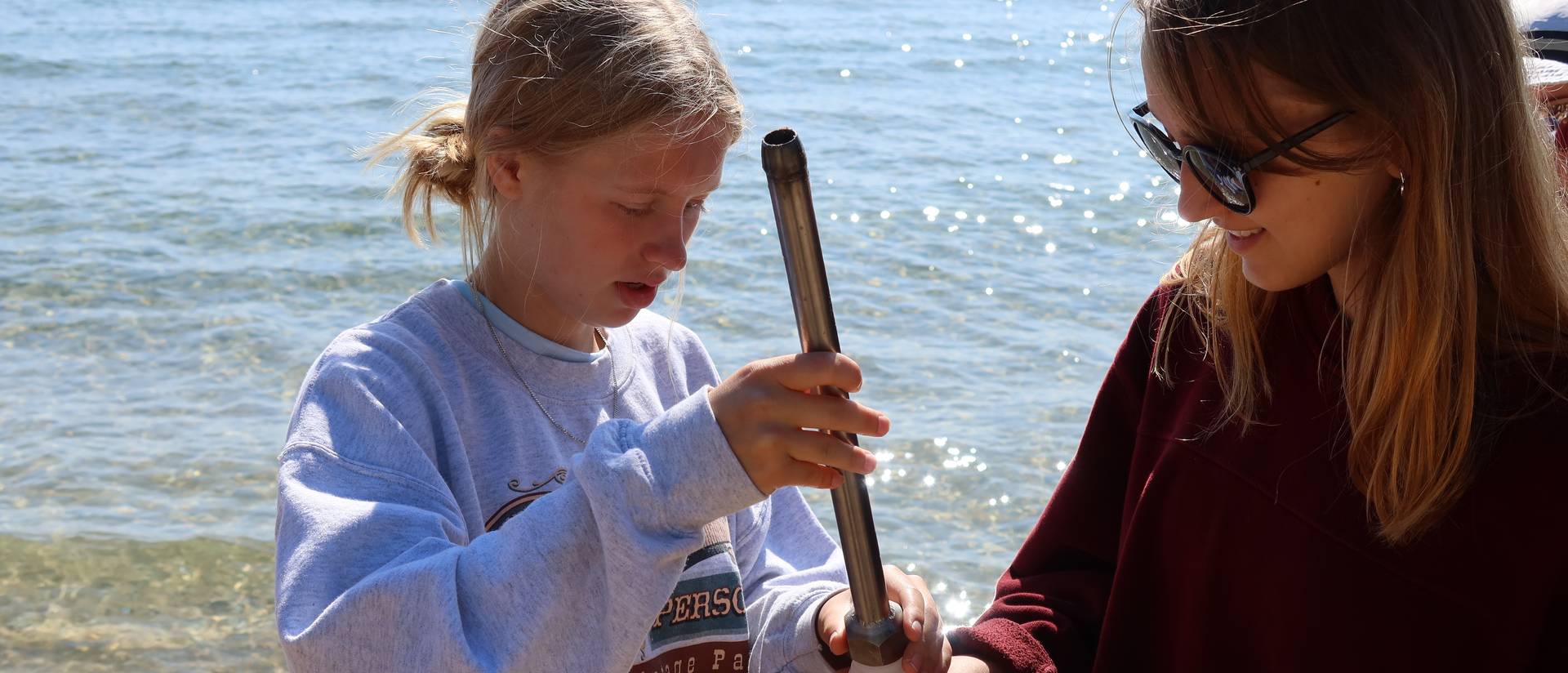 Students testing a water sample on a shoreline