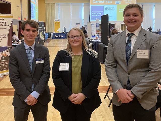 two male one female students in business attire in the Dakota Ballroom of Davies Center, career fair