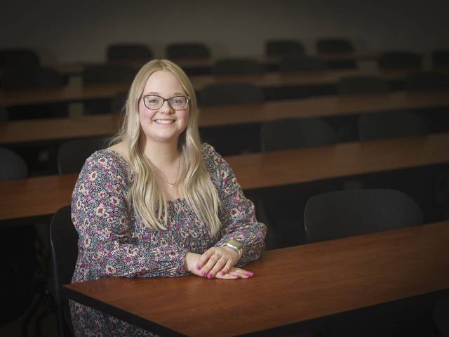 Grace Olson, female NCUR research student sitting at a desk, long blond hair, smiling.