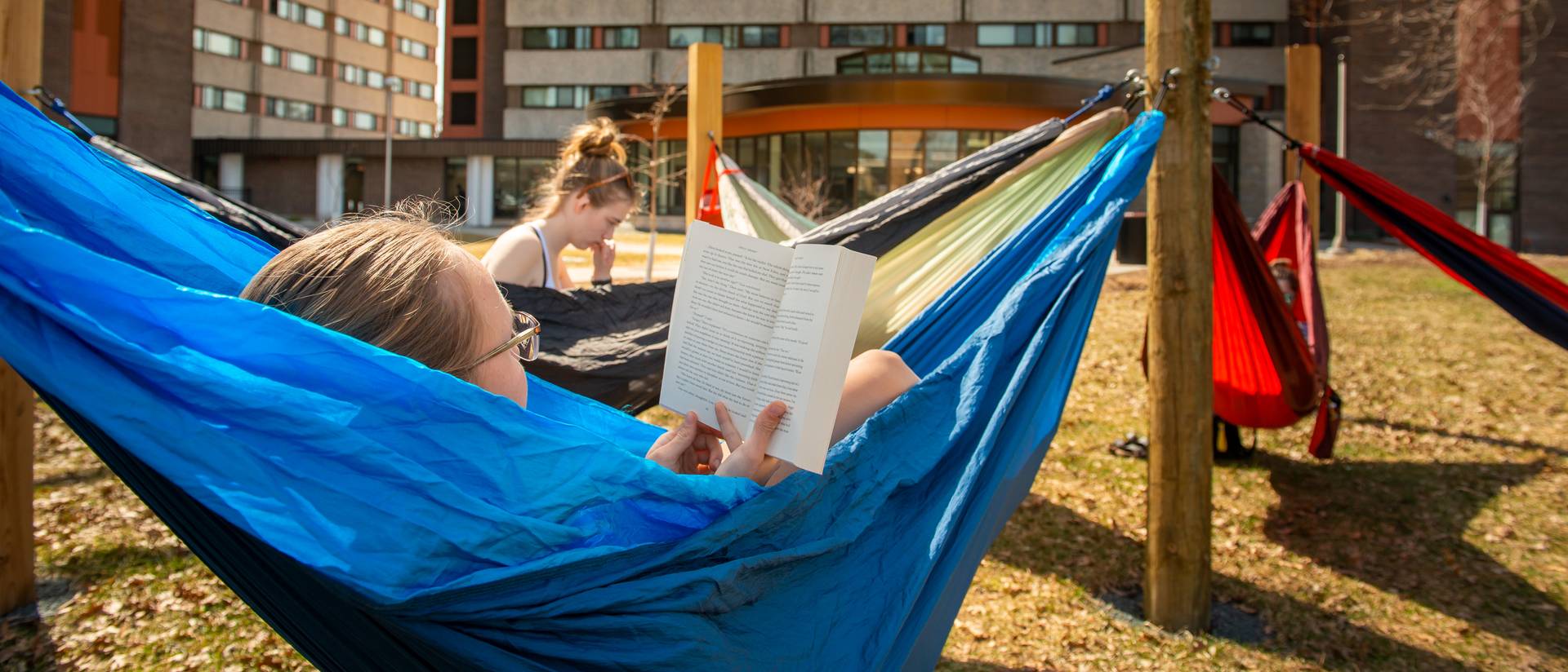 girls in hammocks on upper campus at UWEC, reading books