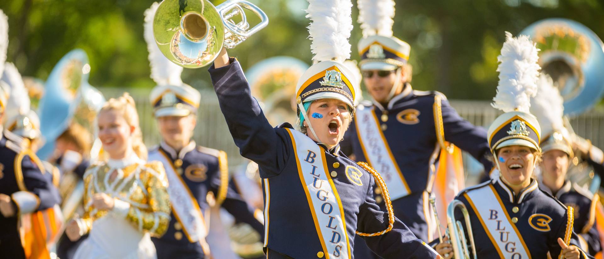 Scenes from the UWEC football game, including the Blugold Marching Band (BMB).