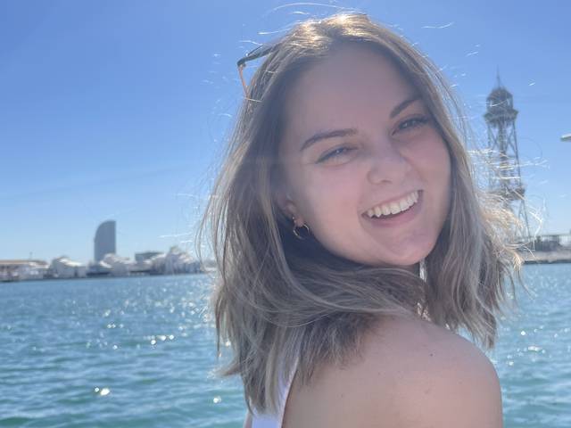 student smiling in front of lake