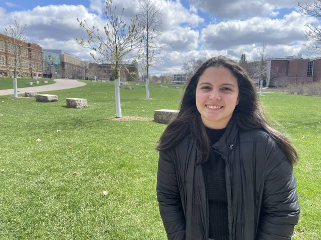 student smiling in grass