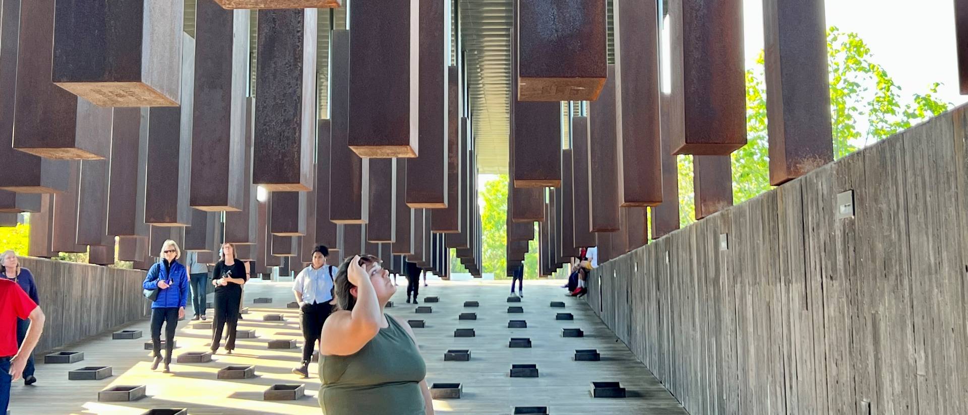 People walking through metal blocks of National Memorial for Peace and Justice