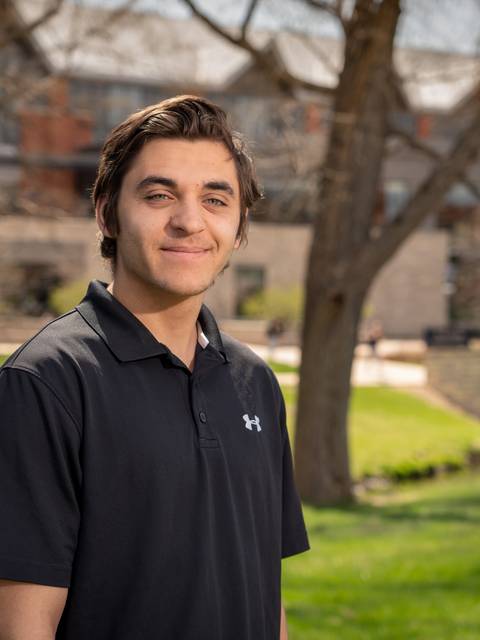 male student, dark hair, sunny day outside Phillips Science hall