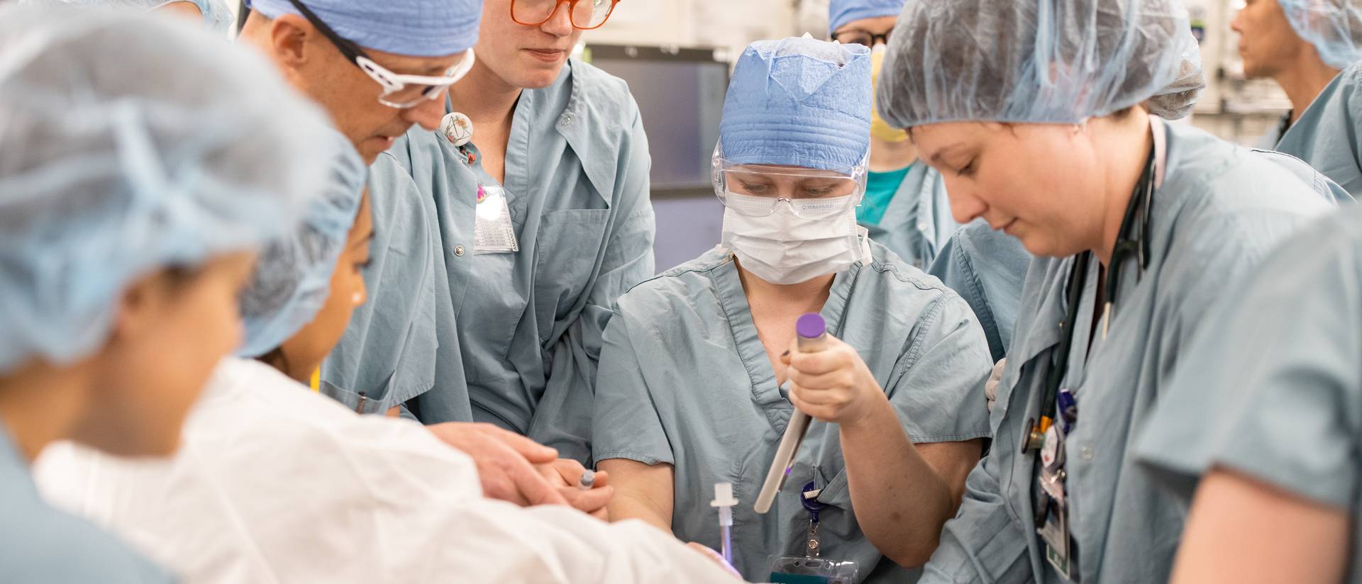 group of medical providers in full scrubs, simulation of code blue