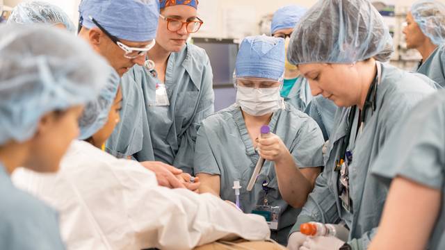 group of medical providers in full scrubs, simulation of code blue