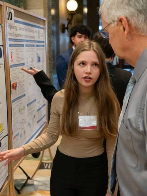 female student presenting research poster in the Madison capitol rotunda