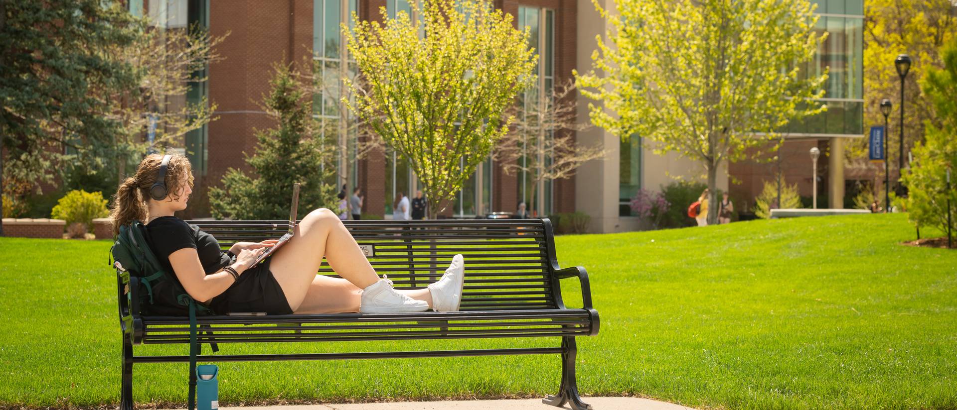 girl sitting on bench studying