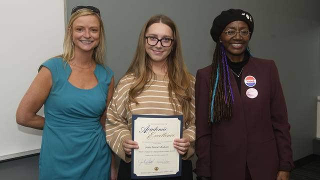 Professors Nicole Schultz and Rose-Marie Avin with student and award.