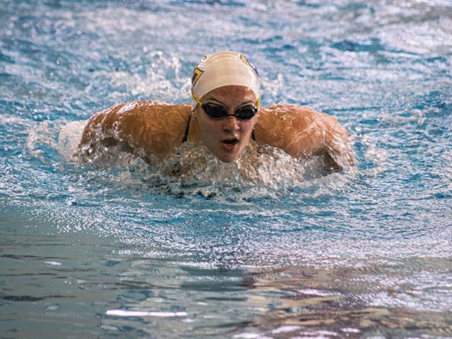 Bella Thovson swimming for Blugolds