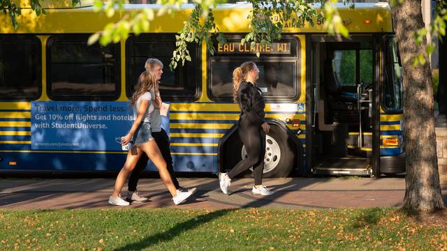 Students walking to enter the city bus on campus