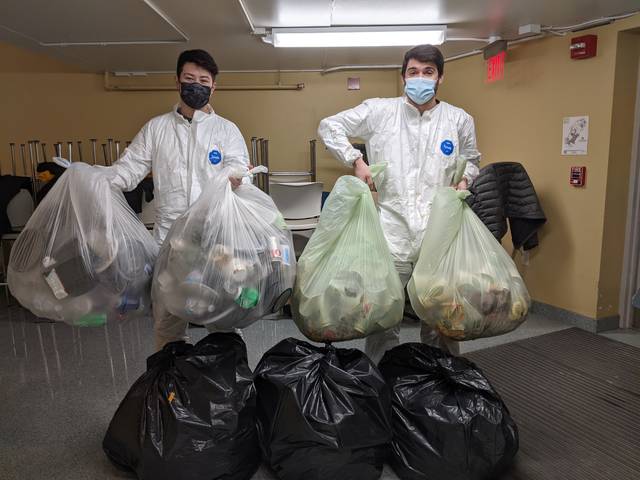 students in hazmat gear sorting food waste and trash in research project about waste