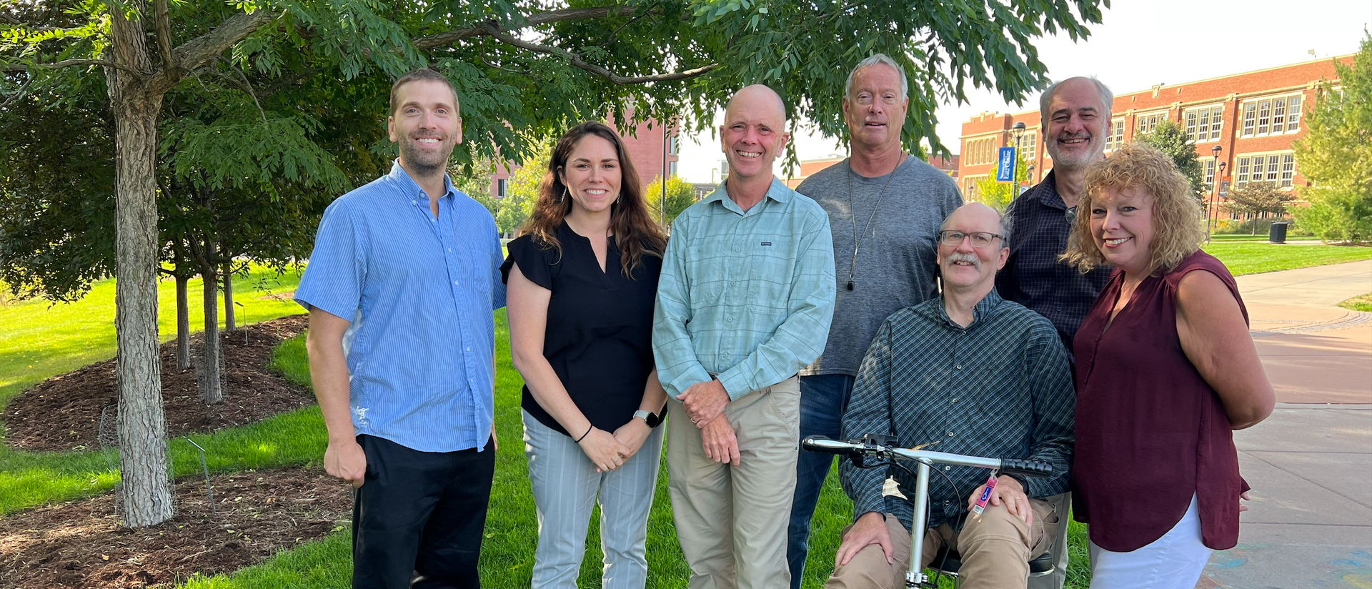 Geology and Environmental Service Faculty stand in a group outdoors on a sunny fall day