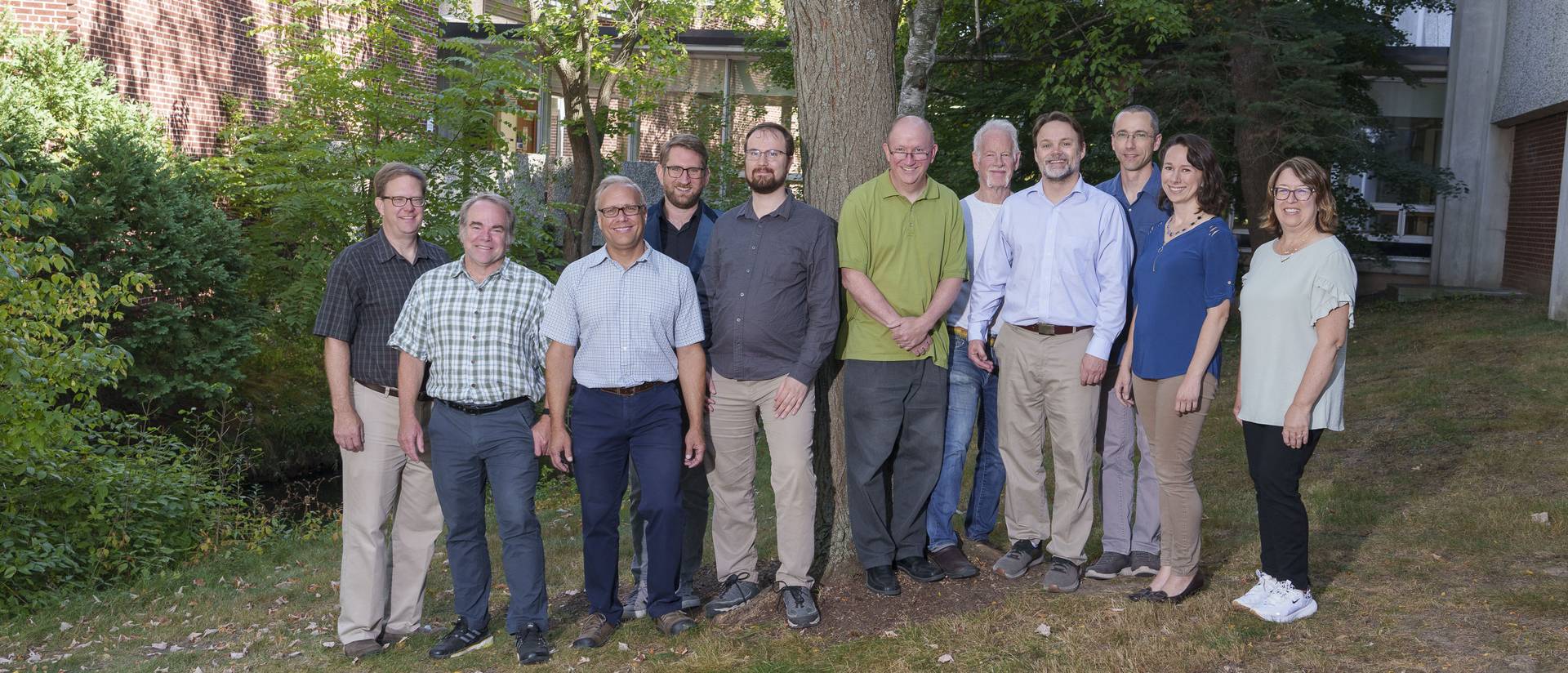 The faculty and staff of the department of physics and astronomy poses outside Phillips Hall.