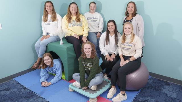 The research group of students and their professor pose in the sensory room they helped design.
