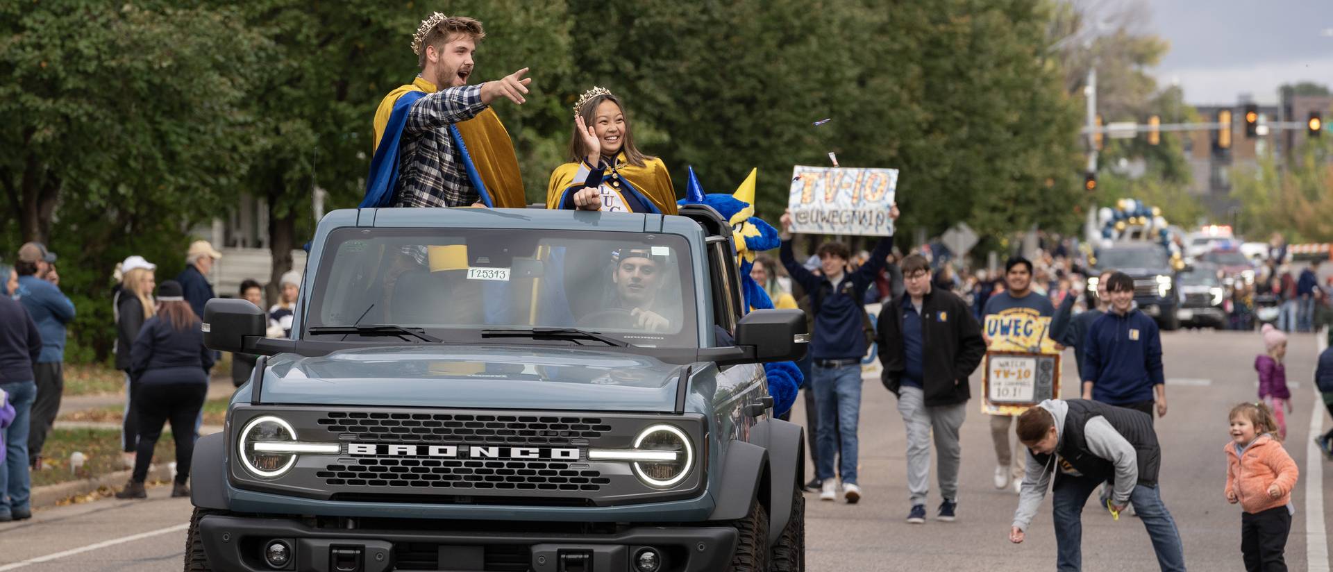 Homecoming royalty in a Bronco during 2023 Homecoming parade for UWEC