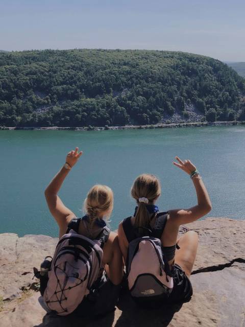Christine and friend pose with peace signs in front of Devil's Lake.